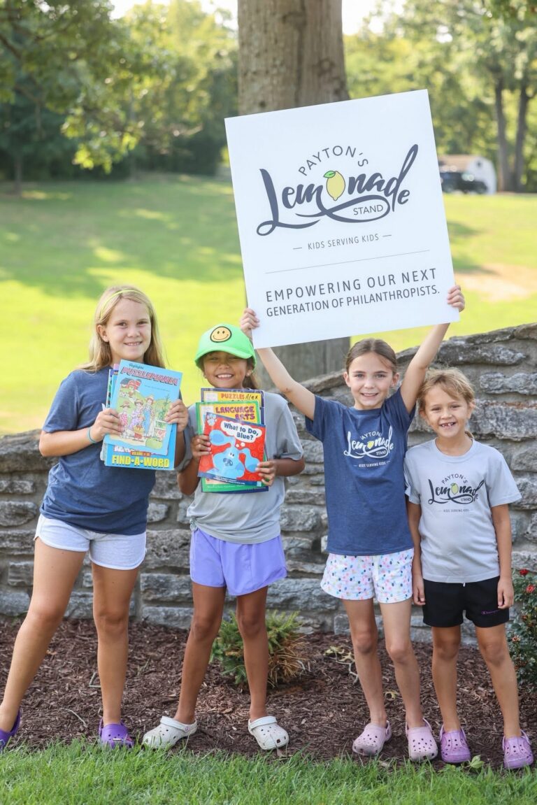 Children holding Payton’s Lemonade Stand sign at community fundraising event