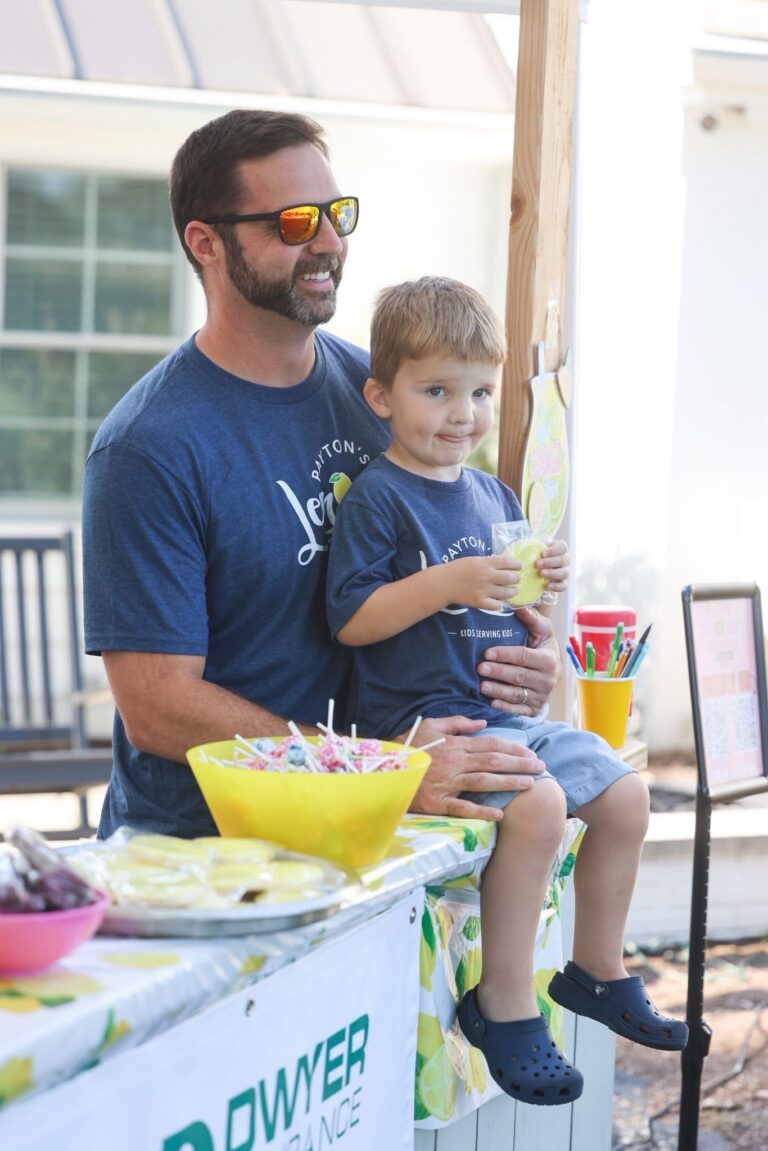 Tom Lipps, Service Manager at Lipps Electric, holding his son at a Payton’s Lemonade Stand community fundraiser.