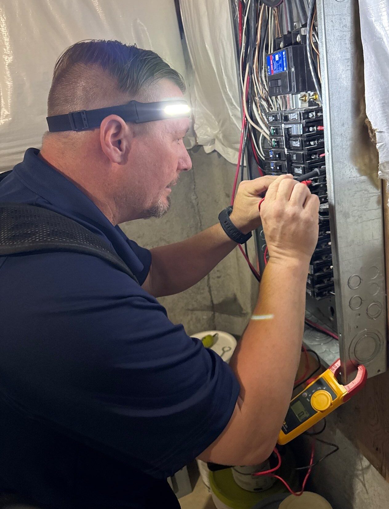 Lipps Electric technician diagnosing an electrical panel during an electrical repair in Greater Cincinnati.